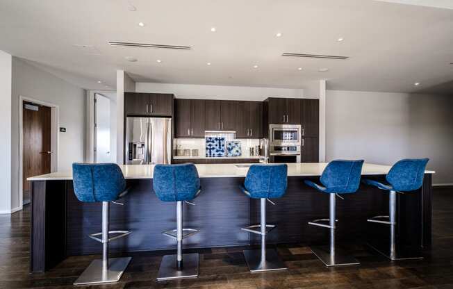a kitchen with a island and blue bar stools