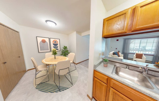 a dining room with a table and chairs and a kitchen with a sink