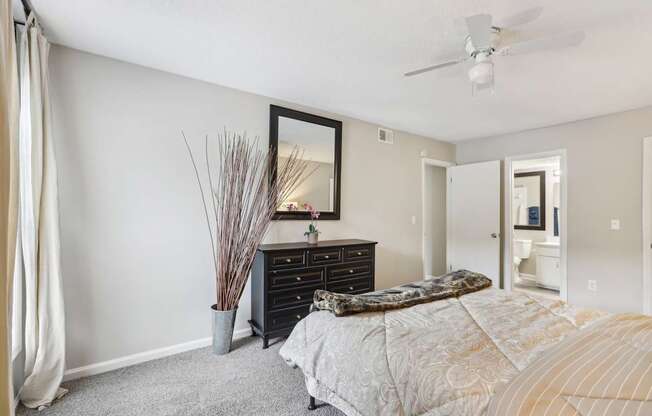 A bedroom with a bed, dresser, and mirror.