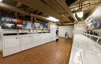 a laundry room with white washers and dryers