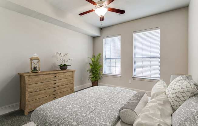 an empty bedroom with a bed and a ceiling fan