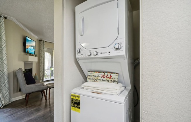 a washer and dryer in a kitchen with a living room in the background