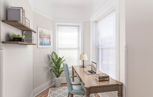 a home office with a desk and two windows