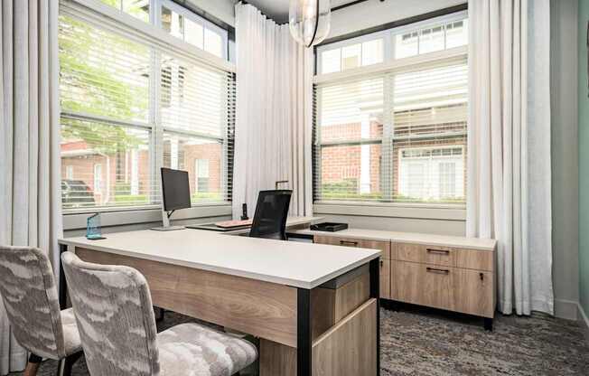 A room with a desk, chair, and two monitors.