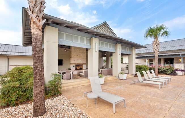 a patio with lounge chairs and a fire pit