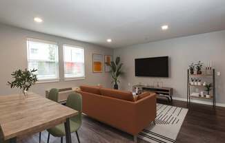 A living room with a brown couch, a wooden table, and a television.