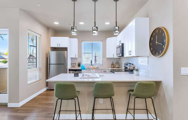 a kitchen with a island with three stools at Solace at Ballpark Village, Goodyear, AZ, 85338