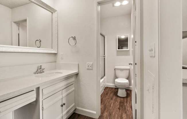 Single vanity area with white quartz countertops, white cabinets bathroom on the right