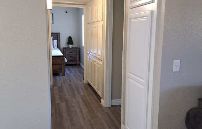 A hallway with a bedroom at the end.