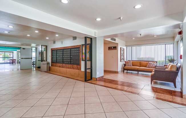 a lobby with a couch and chair and a chalkboard on the wall