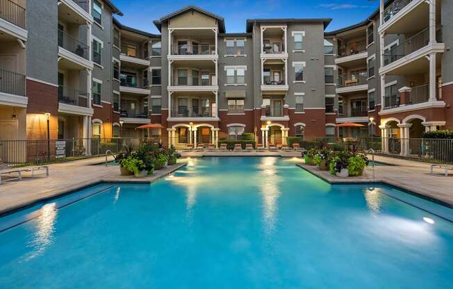 A large swimming pool in front of apartment buildings.
