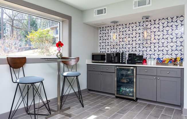 a kitchen with a bar and stools and a window