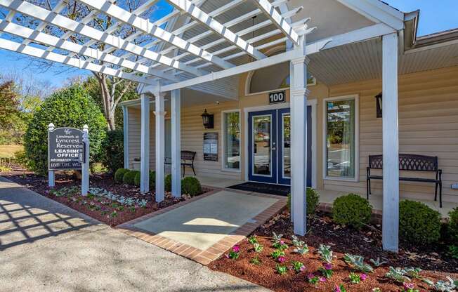 the front porch of a house with a sign and a covered walkway