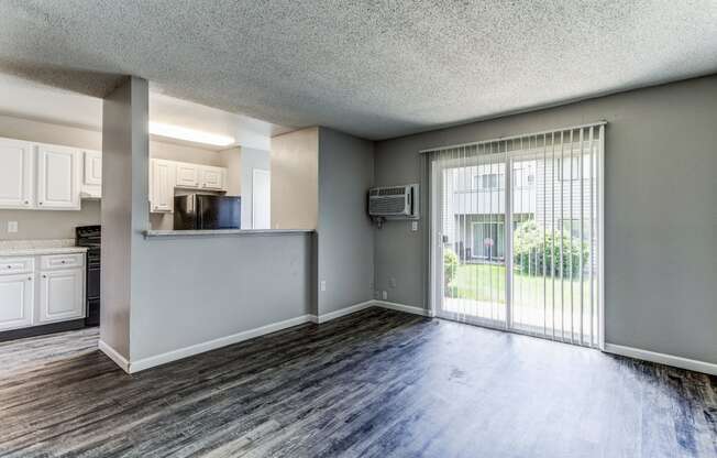 Empty living room and kitchen  at Union Heights Apartments, Colorado Springs, COwith a sliding glass door