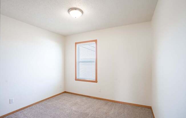 A room with a window and carpeted floor. West Fargo, ND Sheyenne Terrace Townhomes