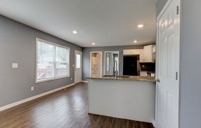 Two Story Duplex With Hardwood Flooring and White Cabinetry