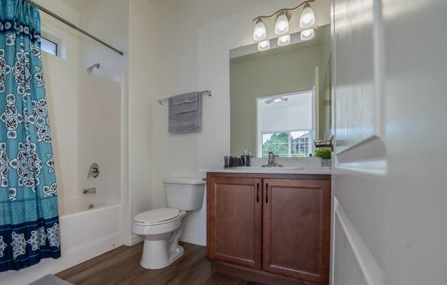 a bathroom with a toilet sink and shower and a mirror