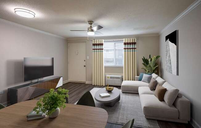 A modern living room with a flat screen TV, a sofa, a coffee table, and a potted plant.