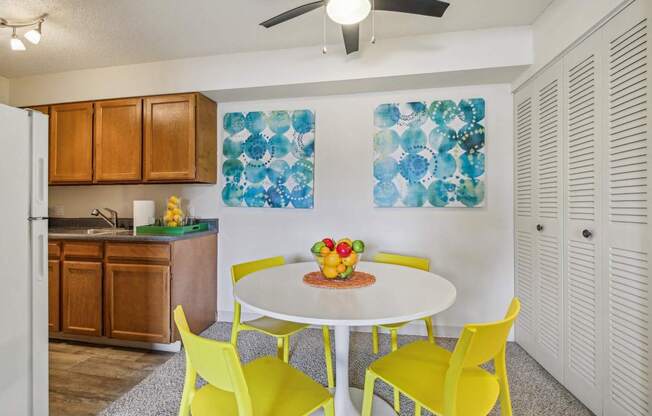 A kitchen with a table and chairs.
