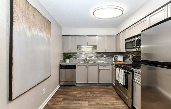 a kitchen with stainless steel appliances and a wooden floor