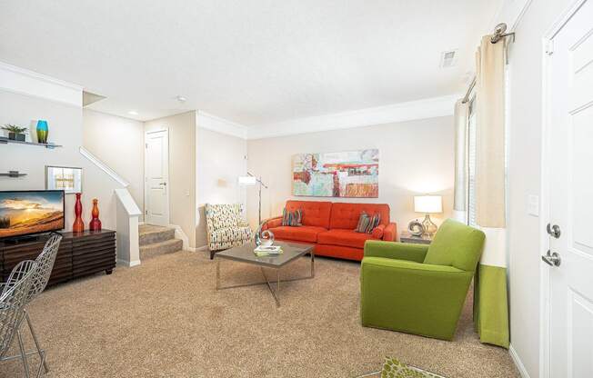 a living room with a red couch and a green chair