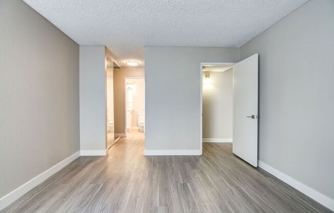 an empty living room with white walls and wood floors at La Jolla Blue, San Diego, CA 92122