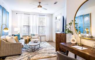 Living room with a couch and a coffee table and a mirror at The Parker Austin, Pflugerville, TX, 78660