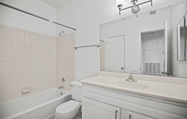 A white bathroom with a toilet, sink, and bathtub.