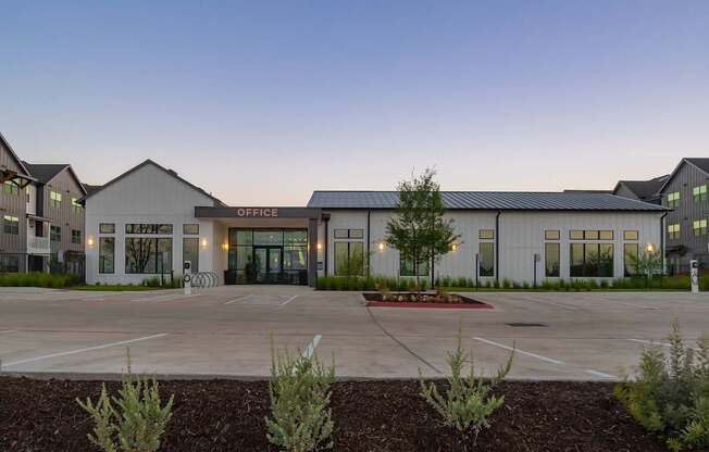 an office building with a parking lot in front of it