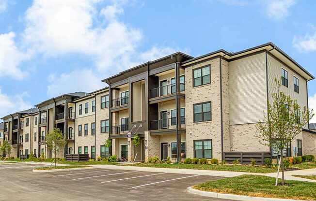 Apartment complex with a parking lot in front.