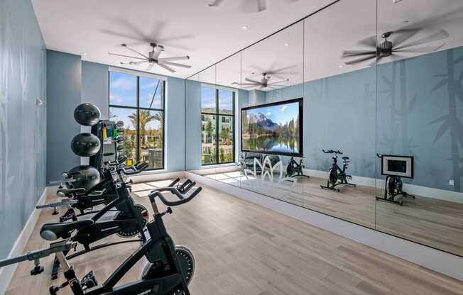 a workout room with mirrors and weights on a wooden floor at Altis Grand Suncoast, Land O' Lakes, 34638