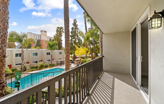 Apartments for Rent in Culver City - Parkway Plaza - View From An Upper Story Balcony Overlooking A Fenced In Pool Surrounded By Palm Trees