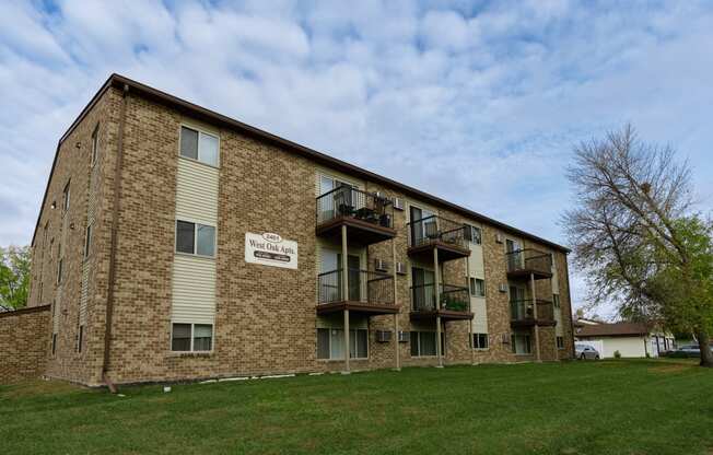 the exterior of a brick apartment building with balconies. Fargo, ND West Oak Apartments.