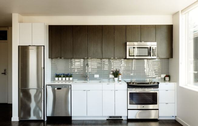 a kitchen with white cabinets and stainless steel appliances