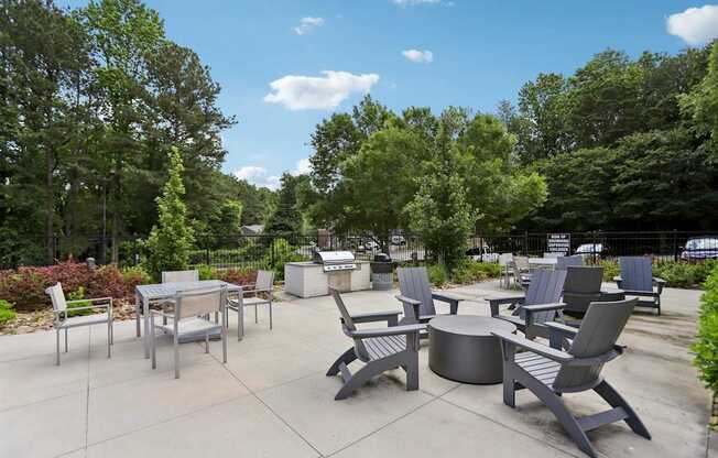 A patio with a table and chairs surrounded by trees.