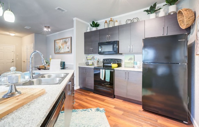 a modern kitchen with stainless steel appliances and wood flooring