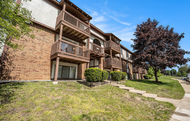 A large brick building with balconies overlooking a green lawn at Seville Apartments, Michigan