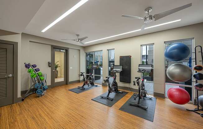 a gym with weights and exercise equipment on a wooden floor