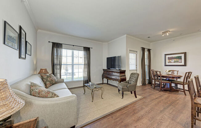 A living room with a couch, chairs, and a piano.