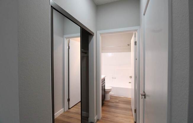 a view of the bathroom from the hallway with a door to the closet