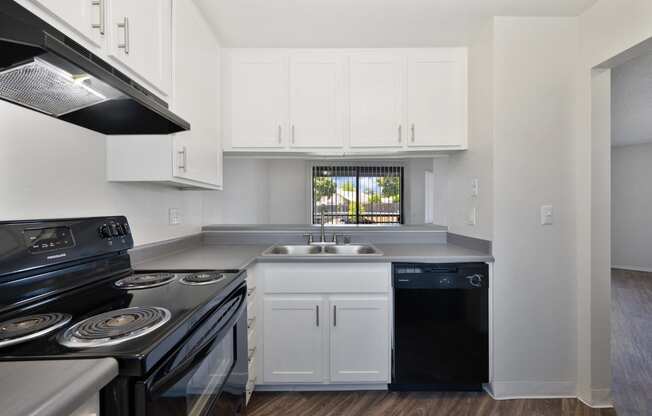a kitchen with white cabinets and black appliances