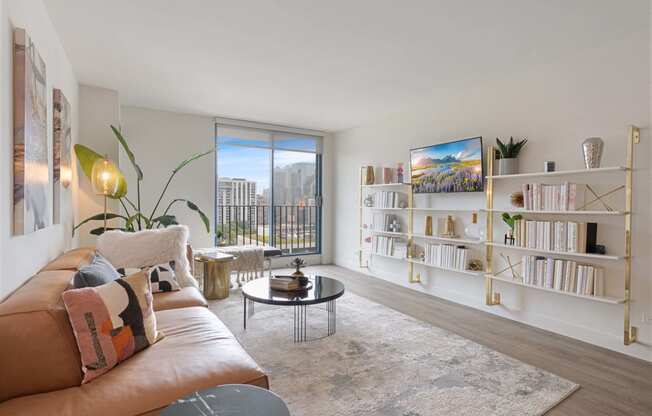 a living room with a leather couch and a large window