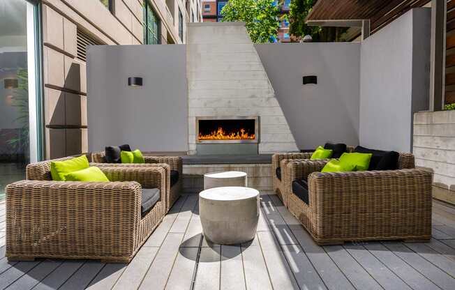 A patio with a fireplace and wicker chairs.