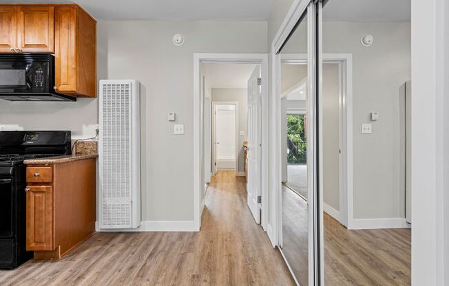 a kitchen with wood floors and white walls