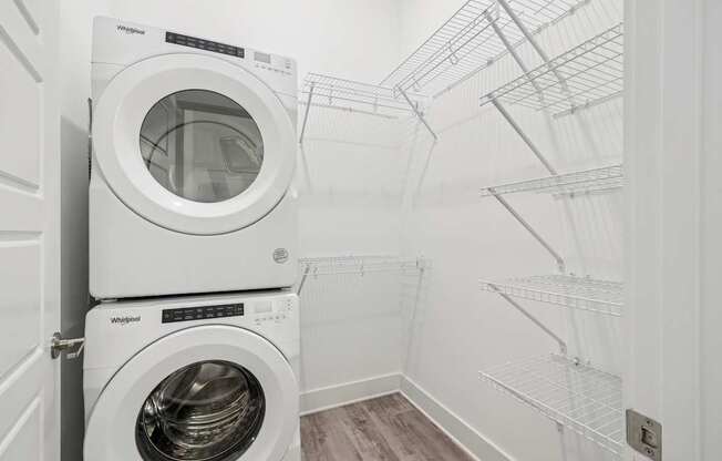A laundry room with a washer and dryer stacked on top of each other at Link Apartments® CYKEL Apartments, Charlotte, NC