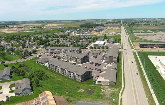 an aerial view of a city with cars parked in a parking lot