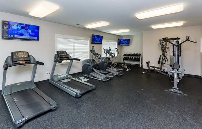 A gym with treadmills, elliptical machines, and exercise bikes.
