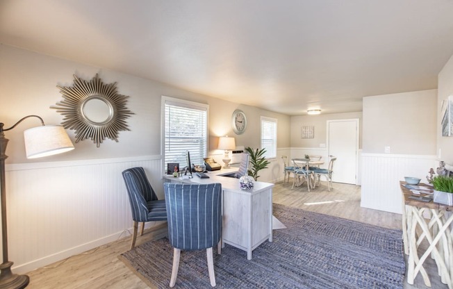 Property office showing comfortable chairs, desk, floor lamp and side table at The Lakes Apartments, Moses Lake, WA.