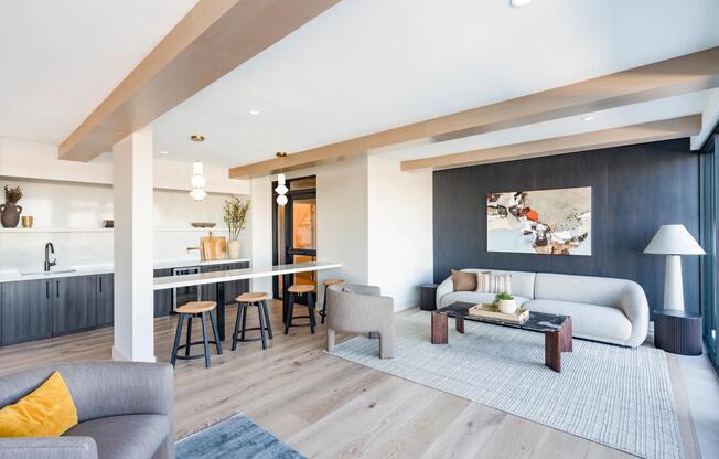 Spacious resident lounge with warm wood accents, comfortable seating, and a sleek entertaining bar.