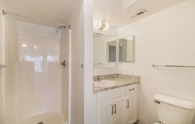 an upgraded bathroom with white cabinetry and a shower at Canal 2 Apartments, Lansing, Michigan